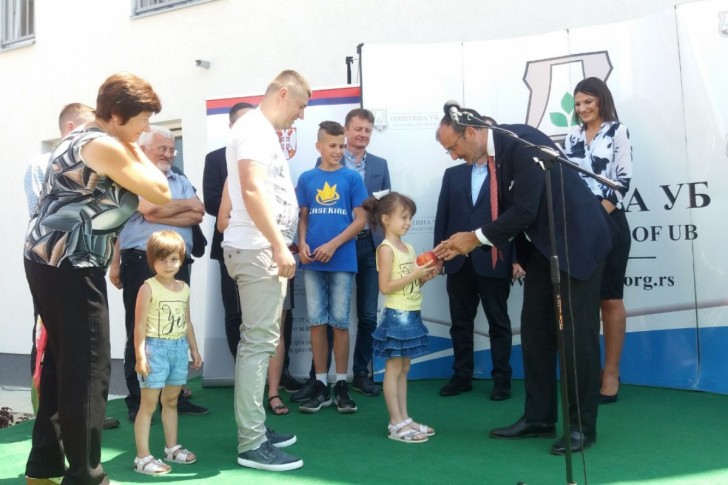 Sem Fabrici daje jabuku devojčici